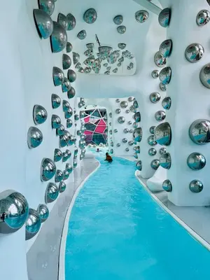 a swimming pool with blue water and silver balls on the wall at Arte Plus by Jerry in Kuala Lumpur