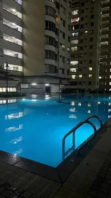 a large swimming pool at night with buildings at Homestay in Kuala Lumpur