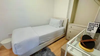 a small bedroom with a white bed and a dresser at Jalan Ampang KLCC Embassy Area Homestay in Kuala Lumpur