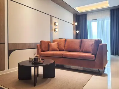 a living room with a brown couch and a table at Cozy Studio Retreat in Kuala Lumpur