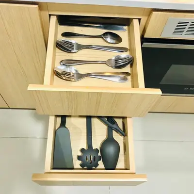 a wooden drawer with utensils in a cabinet at The Colony Infinitum by Manila in Kuala Lumpur