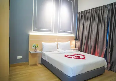 a bedroom with a bed with a red dress on it at The Colony by Klcc Wisma Infinitum in Kuala Lumpur