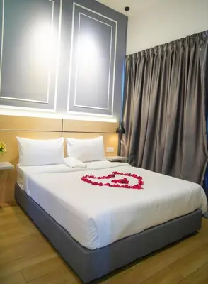 a bedroom with a bed with a red flower on it at The Colony by Klcc Wisma Infinitum in Kuala Lumpur