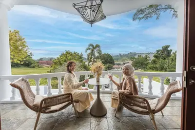 two women sitting around a table on a porch at Provence Chateau Retreat 40 Pax Pool Villa Bangsar by Verano in Kuala Lumpur