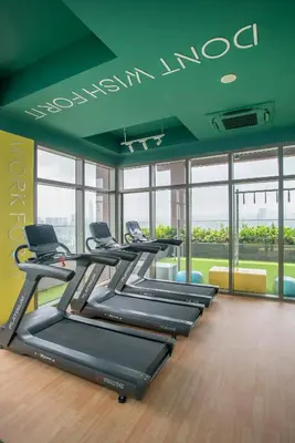 a gym with a row of treadmills at Riveria Sky Residences KL Sentral with Infinity Pool in Kuala Lumpur