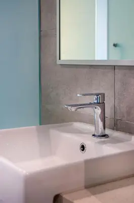 a bathroom sink with a faucet and a mirror at Riveria Sky Residences KL Sentral with Infinity Pool in Kuala Lumpur