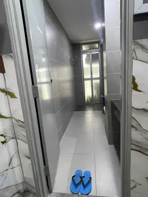 two blue flip flops on the floor of a bathroom at Nour Homestay KLCC View - COZY 1 in Kuala Lumpur