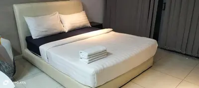 a white bed with towels on it in a room at Summer suite KLCC by Classic Stay in Kuala Lumpur