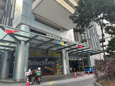 two people riding bikes in front of a merological supermarket at Mercu Summer Suites By comfort Home Stay in Kuala Lumpur