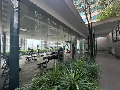 a large glass building with a gym with machines at Mercu Summer Suites By comfort Home Stay in Kuala Lumpur