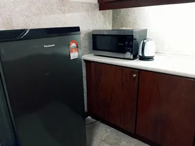 a microwave sitting on top of a counter next to a refrigerator at Maritime Residence at Times Square KL in Kuala Lumpur