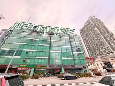 a tall glass building with cars parked in front of it at Cozyhome suites Swiss Garden Residance in Kuala Lumpur