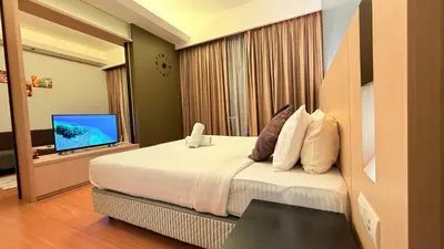 a hotel room with a bed and a television at Cozyhome suites Swiss Garden Residance in Kuala Lumpur