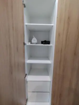 a closet with white shelves and a wooden door at Sky Suites Apartment service in Kuala Lumpur