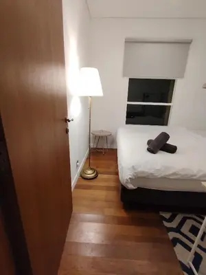 a bedroom with a bed and a lamp on a wooden floor at Sky Suites Apartment service in Kuala Lumpur