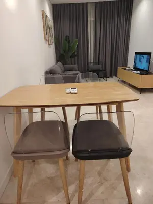 a wooden table and two chairs in a living room at Sky Suites Apartment service in Kuala Lumpur