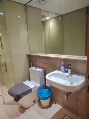 a bathroom with a sink and a toilet and a mirror at Sky Suites Apartment service in Kuala Lumpur