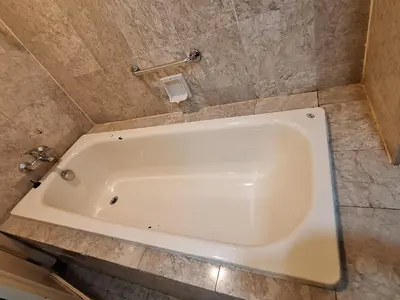 a white bath tub in a bathroom with a tile wall at Time square luxury suites in Kuala Lumpur