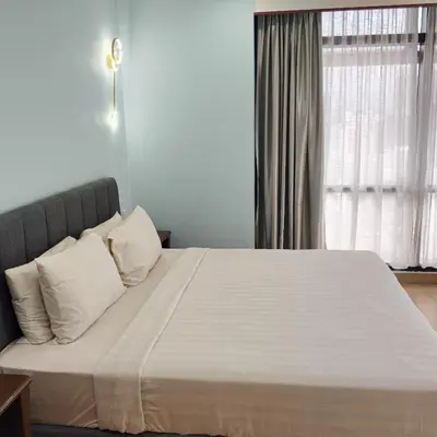 a bedroom with a large bed with white sheets and pillows at Home land apartment by Times Square in Kuala Lumpur