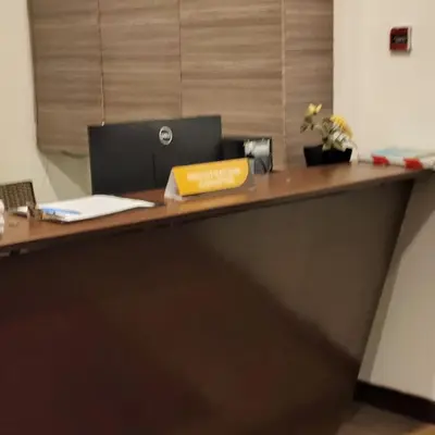 an office desk with a laptop and a book on it at Home land apartment by Times Square in Kuala Lumpur