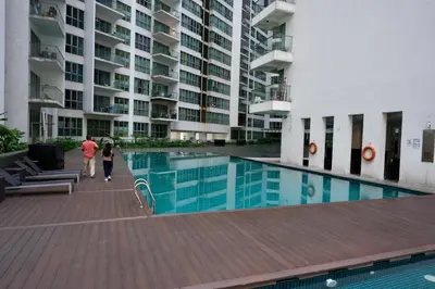 a man and woman walking by a swimming pool in a building at Willow Home in Kuala Lumpur