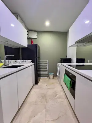 a kitchen with white cabinets and a washer and dryer at Vortex suites klcc by ARICA in Kuala Lumpur