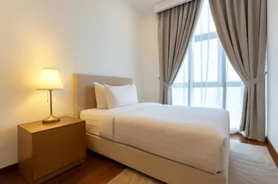 a bedroom with a white bed and a window at Royce Residence KLCC twin tower by ABM Unique in Kuala Lumpur