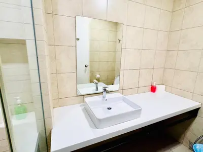 a bathroom with a white sink and a mirror at Robertson Residence by Aspire Suites in Kuala Lumpur
