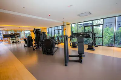 a gym with cardio equipment in a building with windows at M Arisa KL City View by AT in Kuala Lumpur
