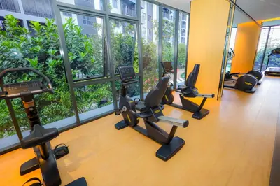 a gym with treadmills and ellipticals in front of windows at M Arisa KL City View by AT in Kuala Lumpur