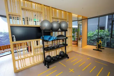 a gym with dumbbells and a wall of wood at M Arisa KL City View by AT in Kuala Lumpur
