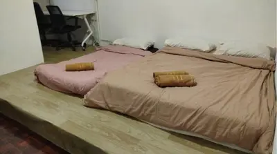 two beds sitting next to each other in a bedroom at Segambut House near MITEC KLCC PWTC 14 paxs in Kuala Lumpur