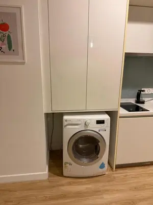a kitchen with a washing machine under a cabinet at Platinum kuala lumpur by Bright Suites in Kuala Lumpur