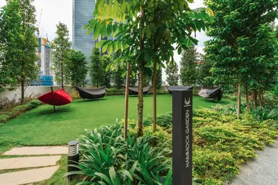 a garden with hammocks and a green yard with trees at Deluxe 2BR Agile Bukit Bintang by RumaBnB in Kuala Lumpur