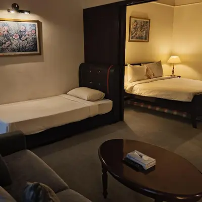 a hotel room with two beds and a coffee table at Home World Apartment At Times Square in Kuala Lumpur