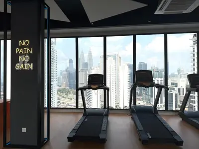 a gym with two treadmills in front of a large window at KLCC Majestic Residence By Vglory Home in Kuala Lumpur
