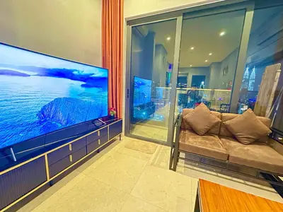 a living room with a couch and a large screen tv at Lucentia Universal Stay Kuala Lumpur in Kuala Lumpur