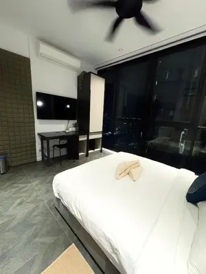 a bedroom with a white bed and a ceiling fan at KLCC View Suites By Scarletz in Kuala Lumpur