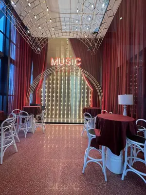 a room with tables and chairs and a music sign at KLCC View Suites By Scarletz in Kuala Lumpur