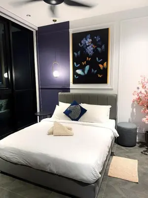 a bedroom with a large white bed with a painting on the wall at KLCC View Suites By Scarletz in Kuala Lumpur
