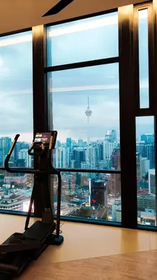 a room with a treadmill in front of a large window at Axon Residence Bukit Bintang Pavilion TRX by Fie in Kuala Lumpur