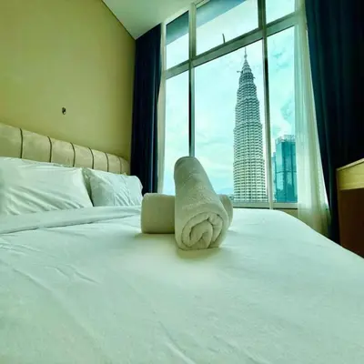 a hotel room with a bed with a towel on it at sky suites klcc by dp in Kuala Lumpur