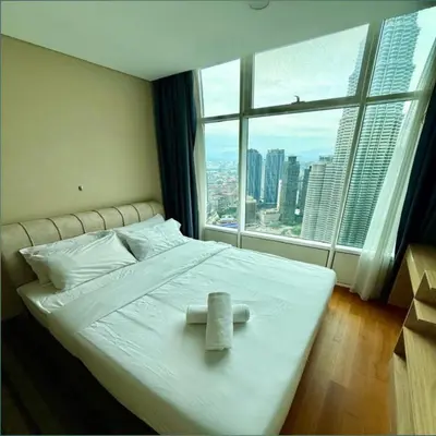 a white bed with a cross on it in a room with a window at sky suites klcc by dp in Kuala Lumpur