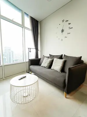 a living room with a couch and a clock on the wall at Tomato Homestay By Sky Suites KLCC in Kuala Lumpur