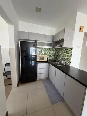 a kitchen with a black refrigerator and white cabinets at Happy Homes 1 Kuala Lumpur in Kuala Lumpur