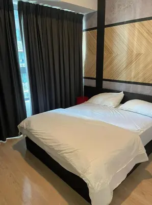 a bedroom with a large bed with white sheets and pillows at Arte Plus Homestay Condo in Kuala Lumpur