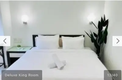 a bedroom with a large white bed and a table at Hotel Bintang Inn in Kuala Lumpur
