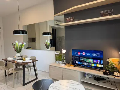 a living room with a table and a large screen tv at The Robertson N9 Jalan Alor Bukit Bintang Petaling Street 7 Pax in Kuala Lumpur