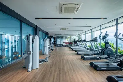 a gym with a row of treadmills and exercise bikes at The Colony By Feel Home in Kuala Lumpur