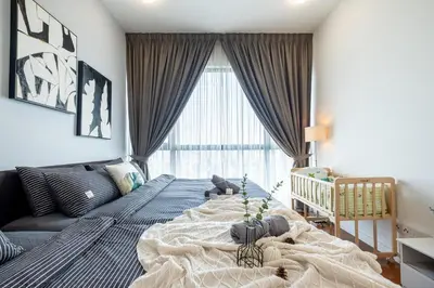 a bedroom with a large bed and a crib at 4 mins to KLCC Luxurious Premium Suite in Three28 in Kuala Lumpur